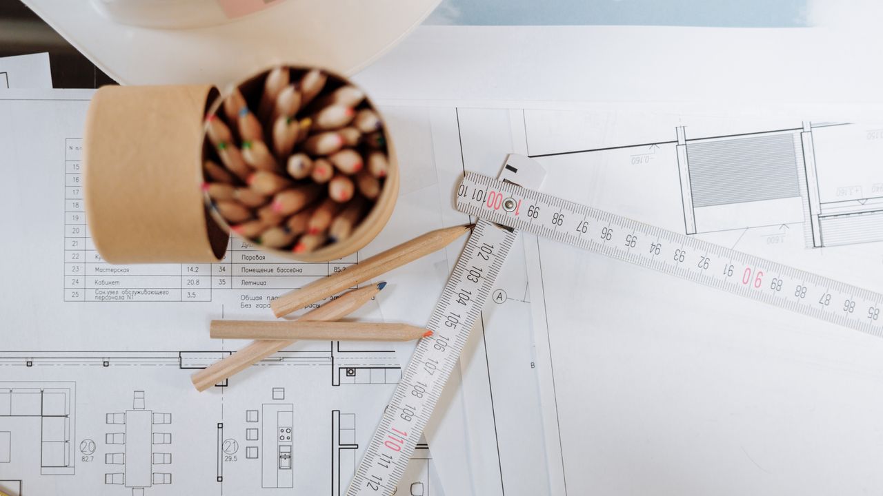 Atelier de arquitetura em Lisboa com plantas e maquetas sobre a mesa de trabalho