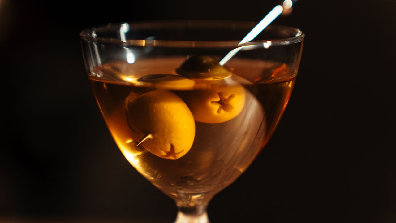Balcão de bar de cocktails com garrafas e iluminação ambiente em Lisboa