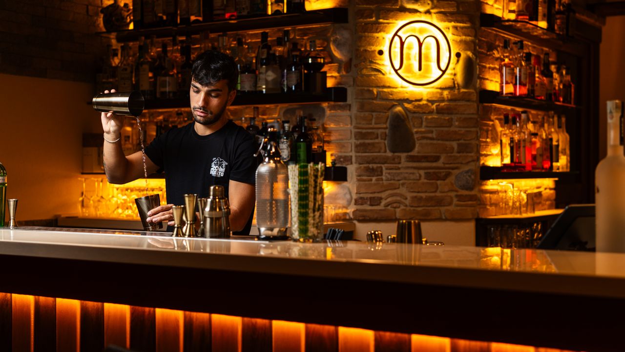 Ambiente noturno de um bar de Lisboa com clientes e iluminação quente