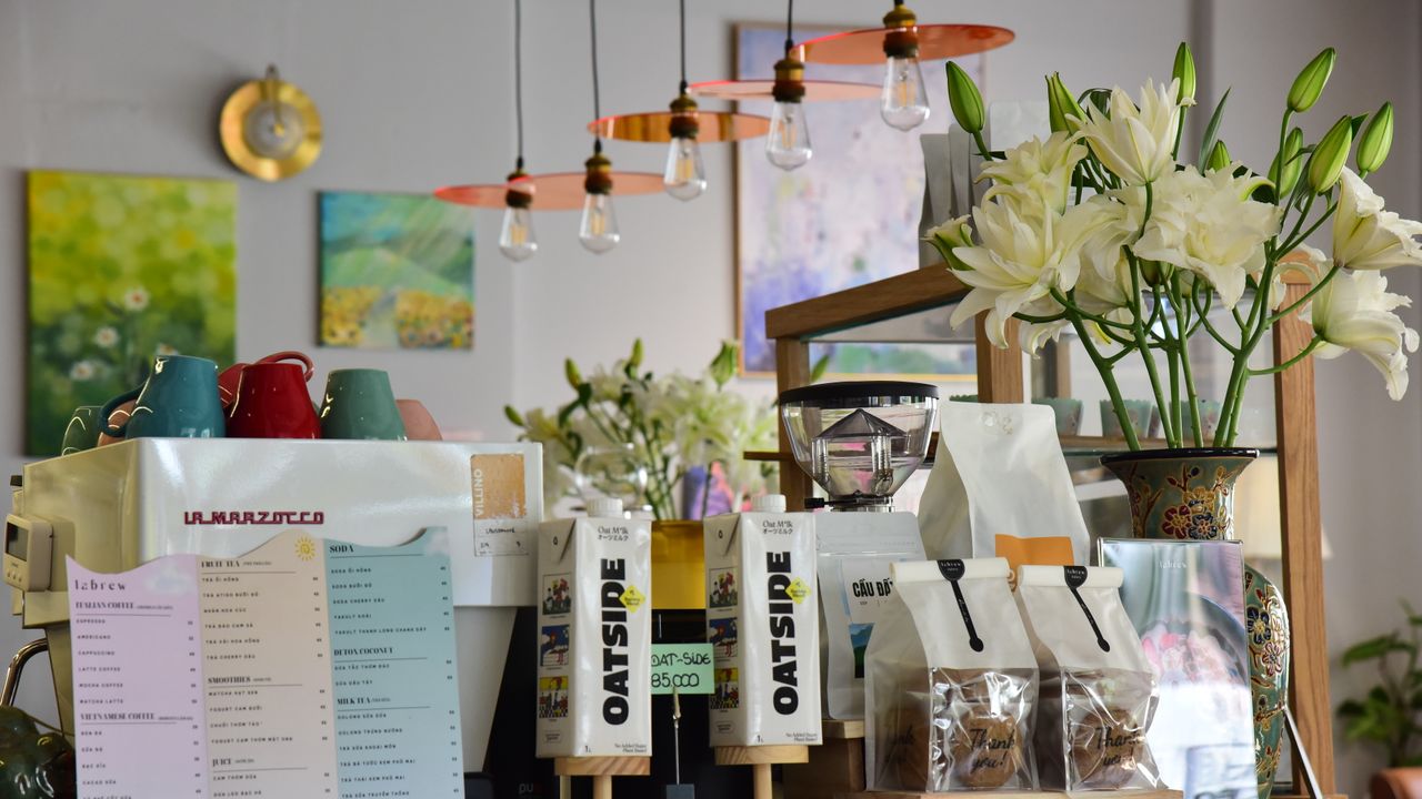 Interior acolhedor de um café em Lisboa com balcão de barista e clientes