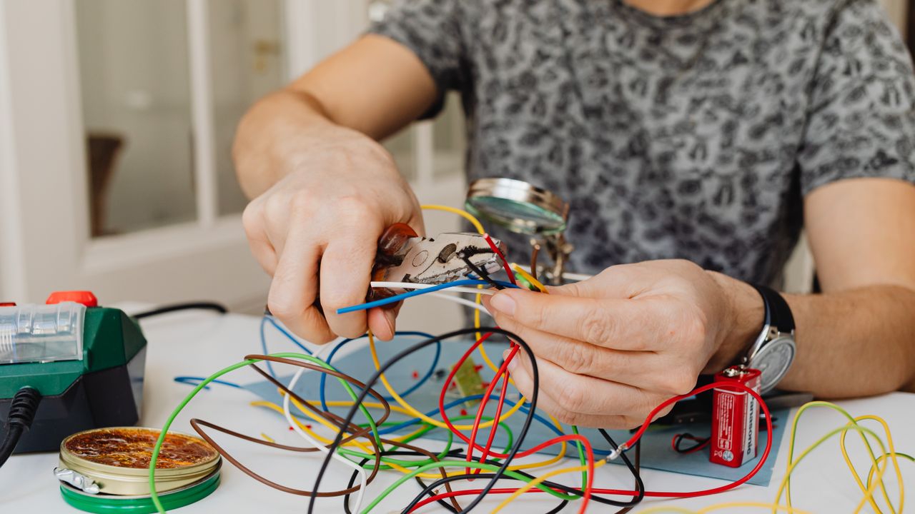Eletricista com equipamento de proteção a verificar uma instalação elétrica em Lisboa