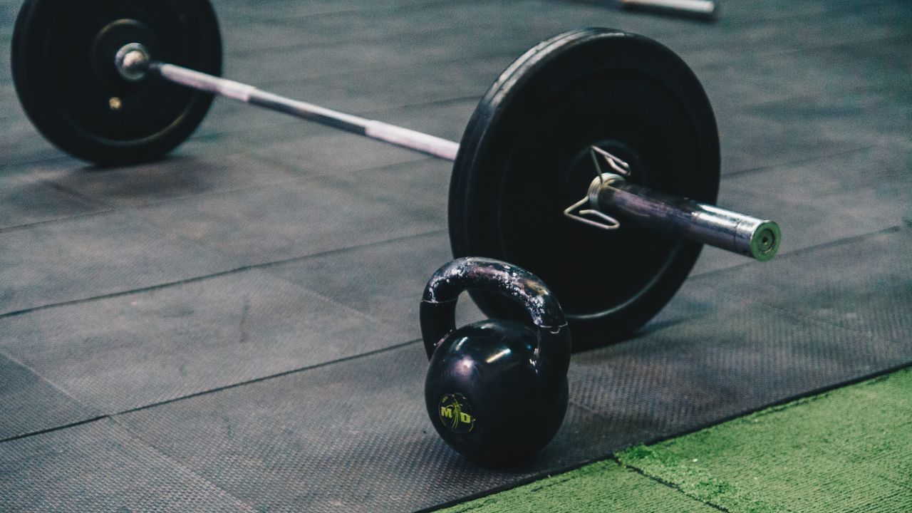 Pessoa a treinar num ginásio em Lisboa com equipamento de cardio ao fundo