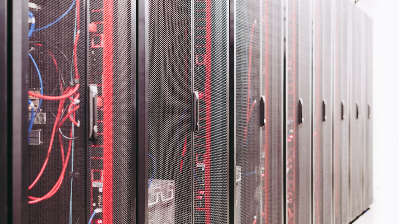 Sala técnica de um fornecedor de serviços geridos com racks de servidores e cabos de rede em Lisboa