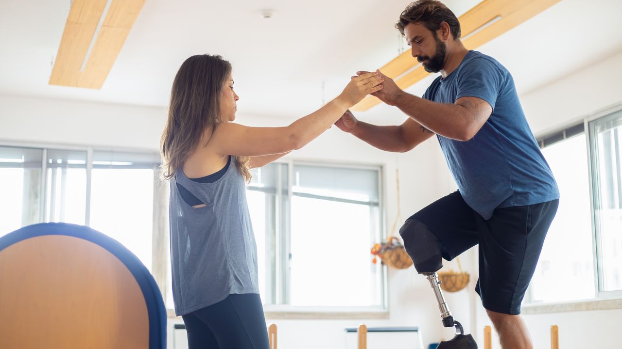 Fisioterapeuta a orientar um exercício de reabilitação com um paciente numa clínica em Lisboa
