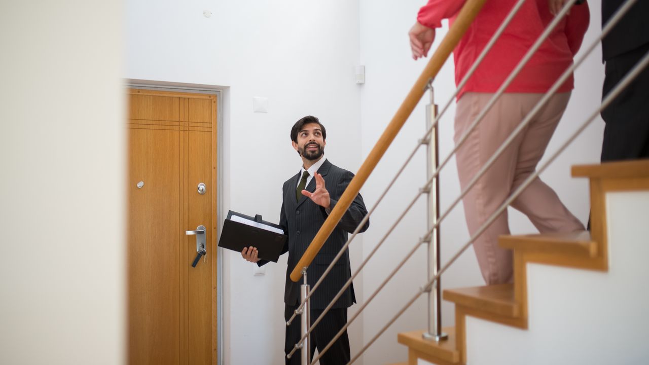 Agente imobiliário a entregar as chaves de uma casa a novos proprietários em Lisboa