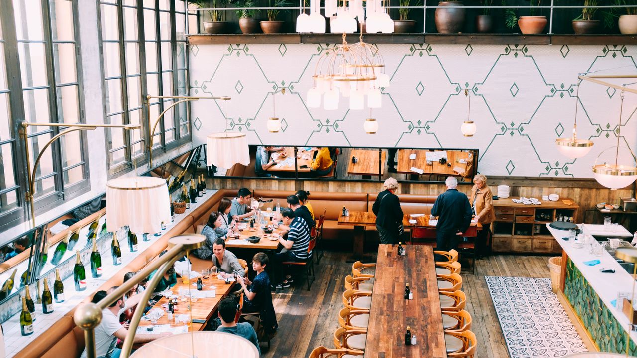 Interior acolhedor de um restaurante em Lisboa com mesas postas e iluminação quente