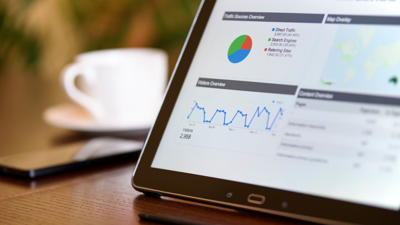 Equipa de uma empresa de SaaS a analisar um dashboard de software em Lisboa