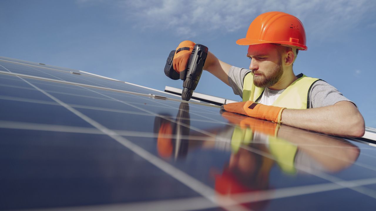 Técnico a instalar módulos solares num telhado de uma habitação em Portugal