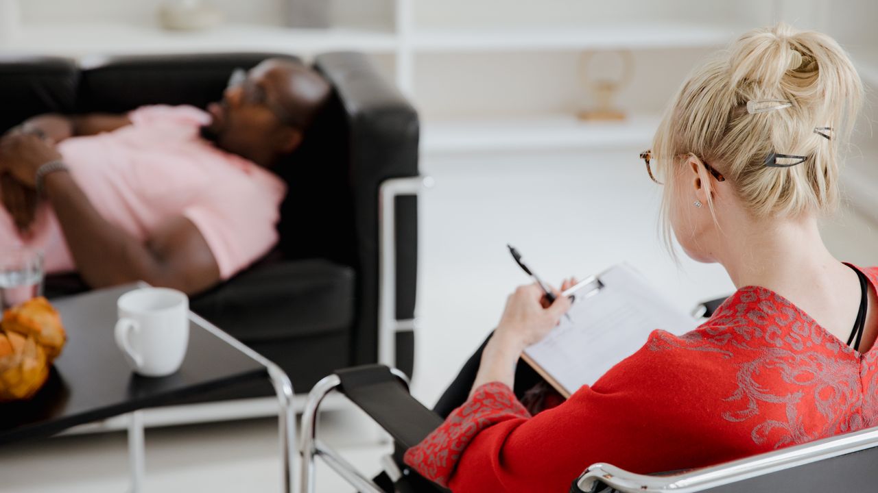 Sessão de terapia acolhedora com terapeuta e cliente num consultório em Lisboa