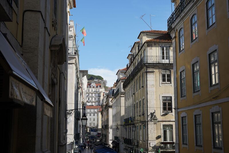 Rua estreita e labiríntica típica de Alfama em Lisboa com prédios antigos