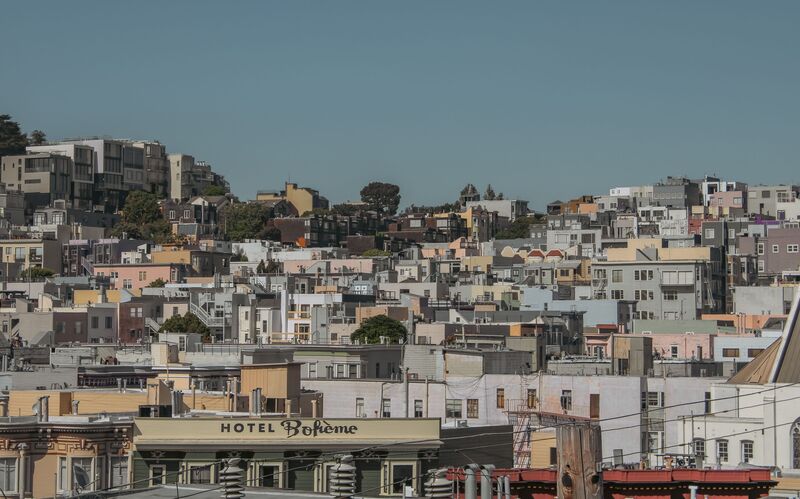 Rua diversa e movimentada no bairro de Arroios, Lisboa, com pessoas e comércio local