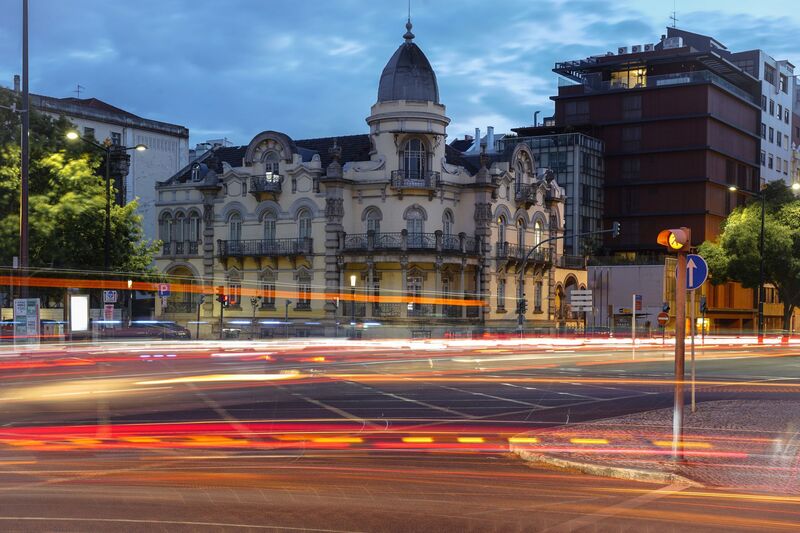 Edifício histórico e cruzamento iluminado à noite perto do Bairro Alto em Lisboa