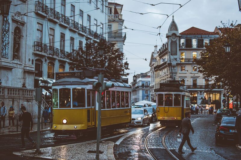 Elétrico amarelo a circular numa rua típica perto do Bairro Alto em Lisboa