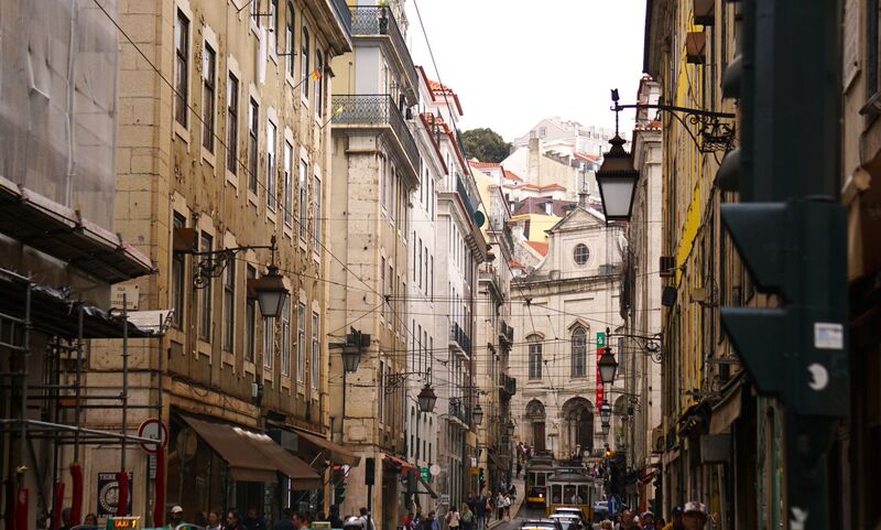 Rua estreita e tradicional do Chiado com fachadas antigas e lojas em Lisboa