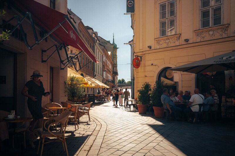 Esplanada de café tradicional com mesas ao ar livre numa rua histórica perto do Chiado