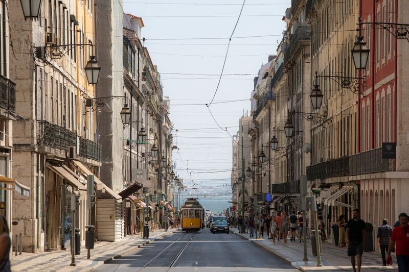 Elétrico tradicional a circular numa avenida do centro histórico de Lisboa junto ao Chiado